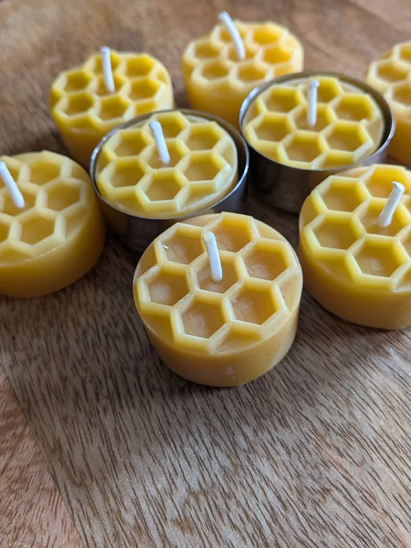 Teelichter aus Bienenwachs mit Wabenmuster, einige in Edelstahlhüllen