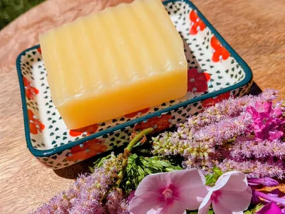 Gelbe Mandarinen-Honigseife in der eckigen, handgefertigten Schale „Flower“ mit roten Blüten